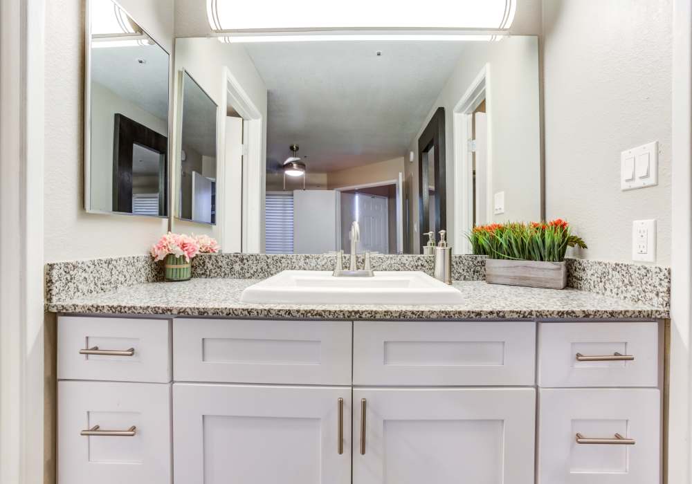 Bathroom with mirror and cabinets at Cabrillo Apartments in Scottsdale, Arizona