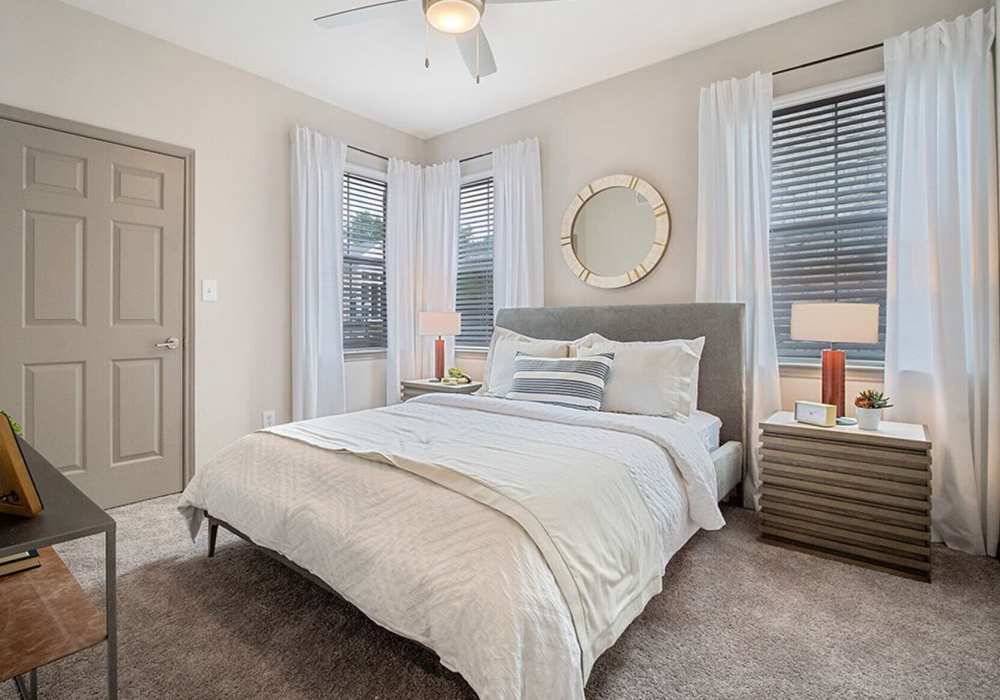 Model bedroom with wood-style flooring at Creekside At Legacy in Plano, Texas