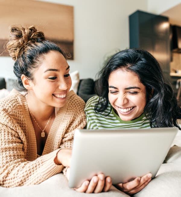 Two women on a couch looking at a tablet together at Liberty Mill in Germantown, Maryland