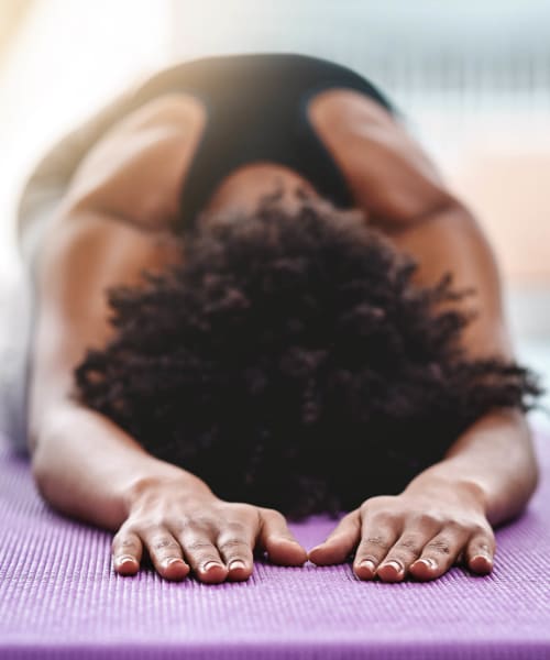 Resident doing yoga in the fitness center at Ramblewood Apartment Homes in Fremont, California
