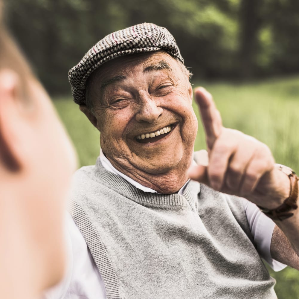 Resident pointing and laughing while sitting outside near Anthology Senior Living in Chicago, Illinois
