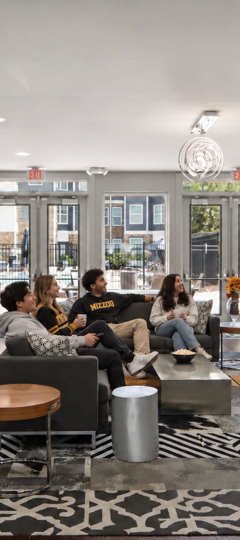 Residents relaxing together in clubhouse lounge at The Den in Columbia, Missouri