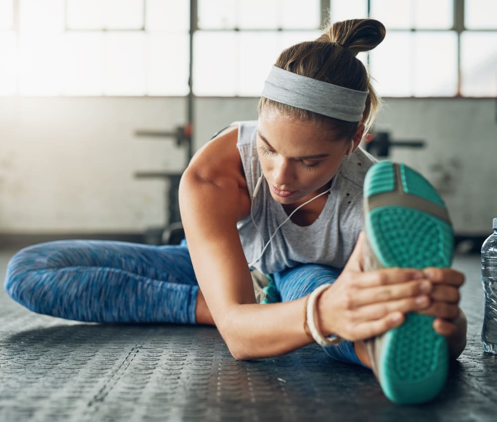 Resident stretching after a workout in the fitness center at Sofi at Somerset in Bellevue, Washington