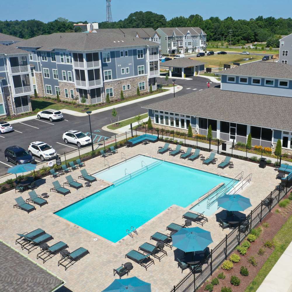 Sparkling resort-style pool with lounge chairs at The Apartments At Kelton Station in Williamsburg, Virginia