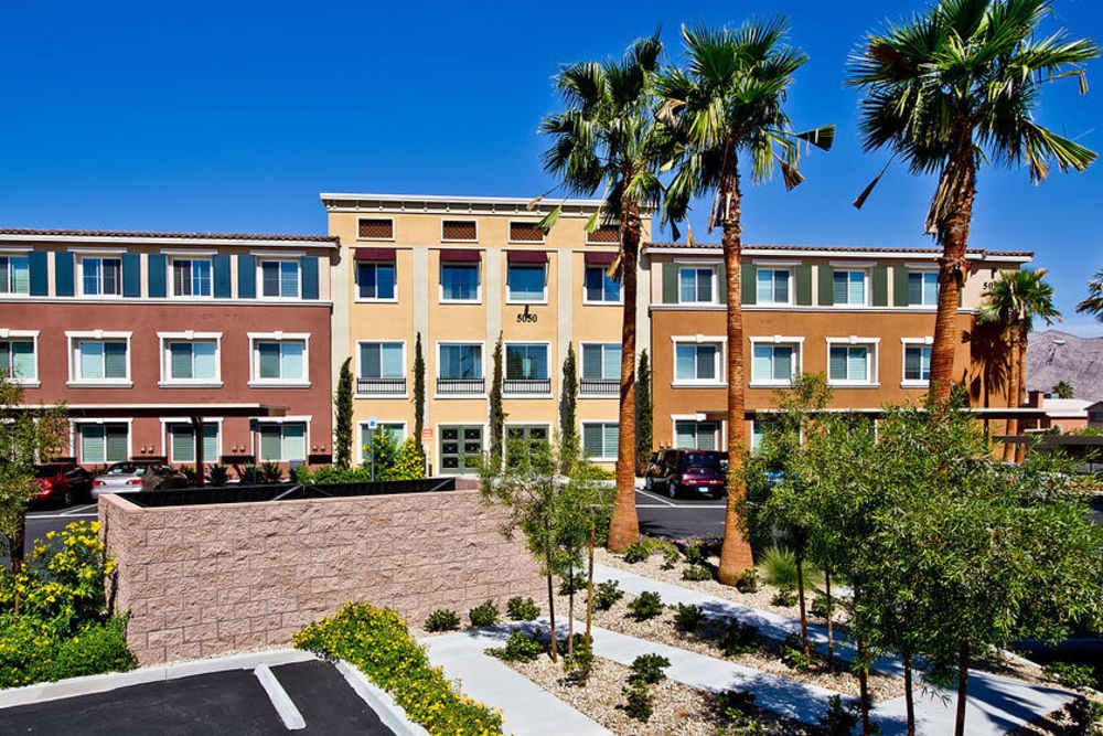 Exterior view of apartments with lush greenery at Acapella in Las Vegas, Nevada