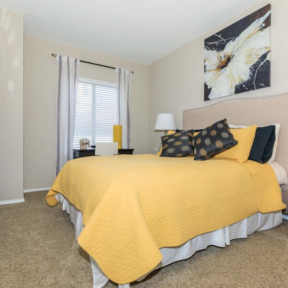 Bedroom with cozy bed and large window at One Belmar Place in Lakewood,Colorado