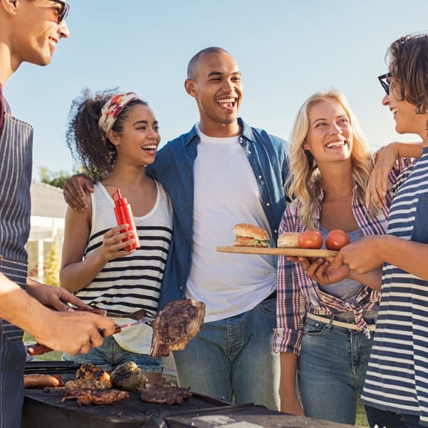 Residents barbecuing outside at Olympus Chandler at the Park in Chandler, Arizona