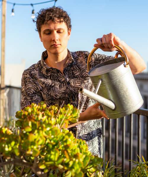 Resident watering plants at Sagewood Estates in Portland, Oregon