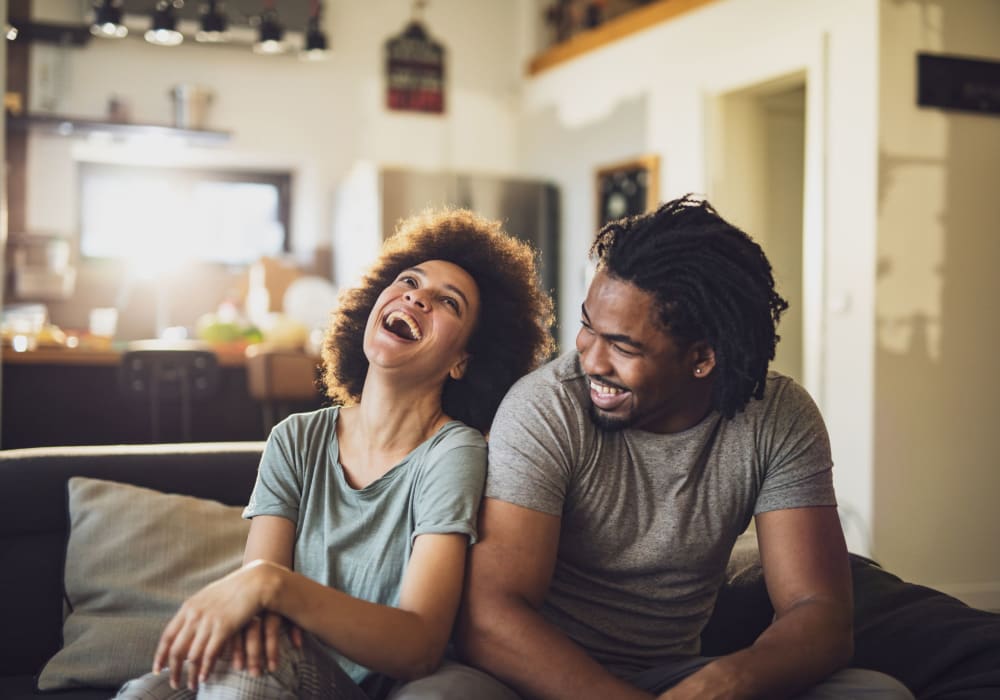 Residents relaxing on their couch and laughing at Autumn Chase in Bothell, Washington