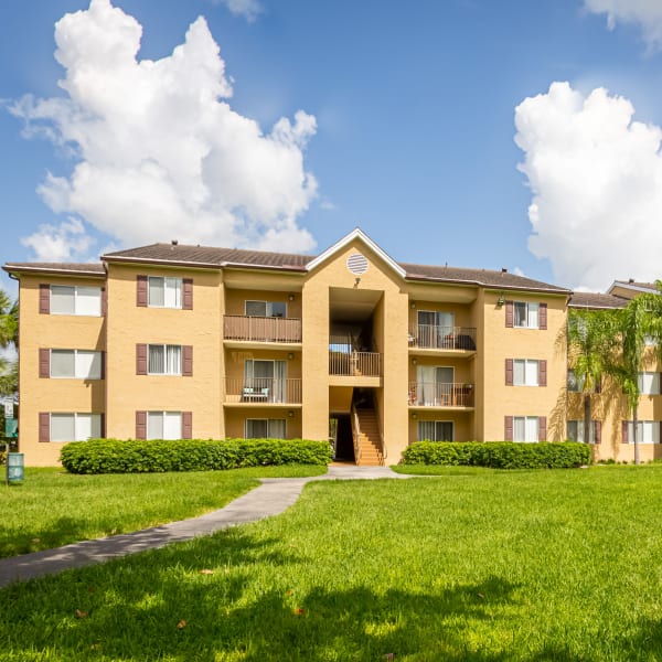 Tennis courts and a paved walking path at Palmetto Place Apartments in Miami, Florida