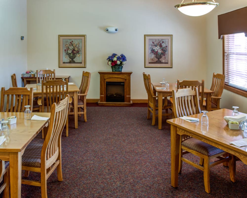 Intimate resident dining room with fireplace at Addington Place of Clinton in Clinton, Iowa.