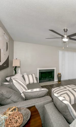 Living room with a fireplace and ceiling fan at Rivercrest in Waco, Texas