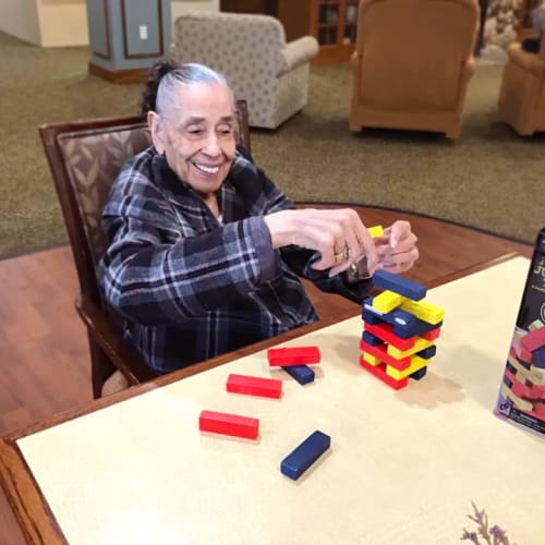 Resident playing jenga at Oxford Glen Memory Care at Grand Prairie in Grand Prairie, Texas