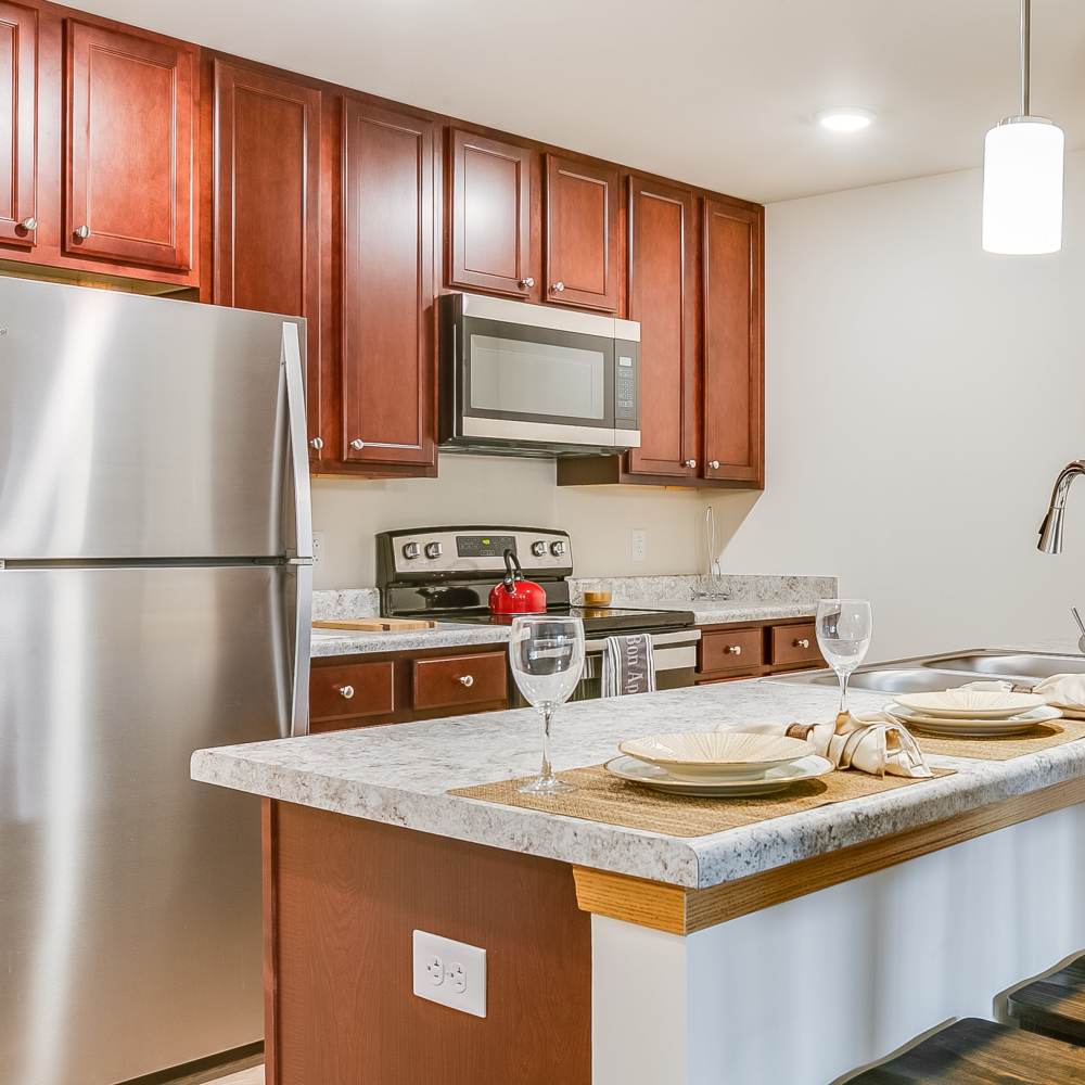 Kitchen available with range, refrigerator and wooden cabinets at Chelsea Commons in Sugar Grove Illinois