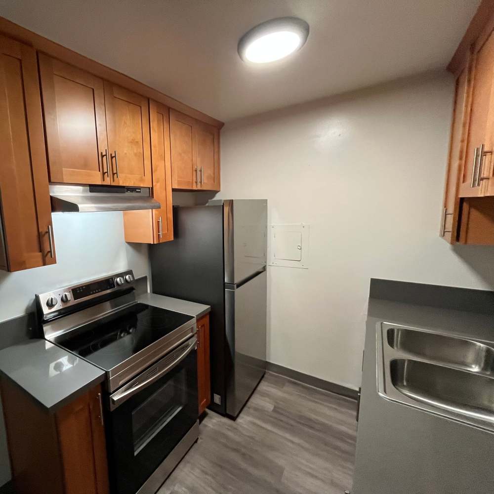 Cute kitchen with white appliances at Valley Pride Village in Sylmar, California