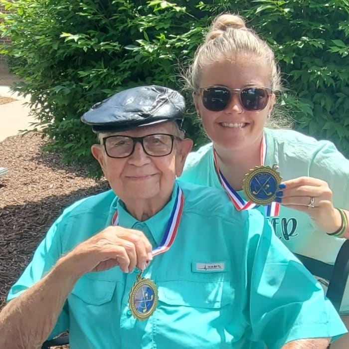 Resident and care taker showing their Olympic game medals from an Olympic event at The Clinton Presbyterian Community in Clinton, South Carolina