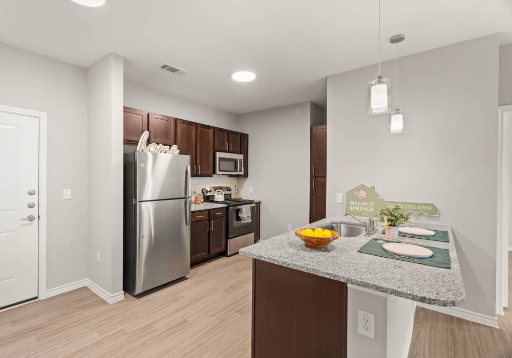 Kitchen with island and appliances at Walnut Springs in Seguin, Texas