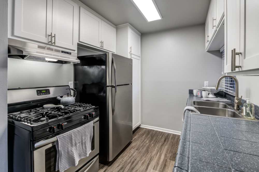 A renovated kitchen with white cabinets at Kendallwood Apartments in Whittier, California