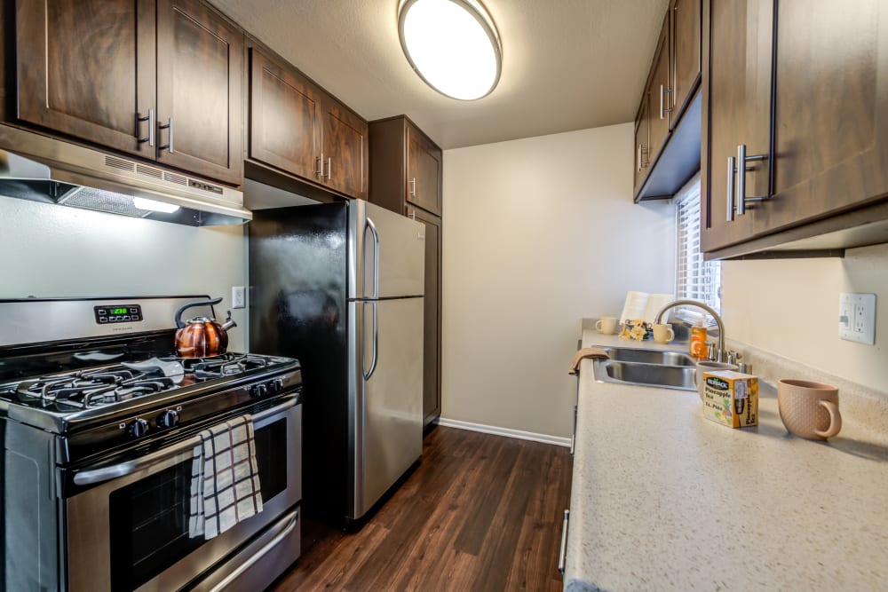 Kitchen with wood-style flooring at Kendallwood Apartments in Whittier, California