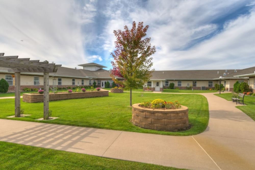Courtyard with a green lawn and paved walkways at Addington Place of Muscatine in Muscatine, Iowa