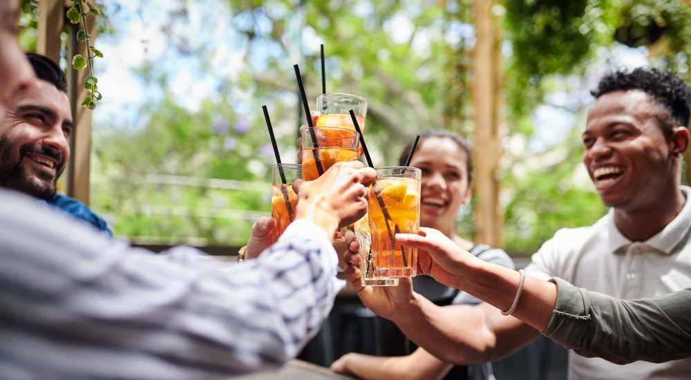 Residents enjoying drinks at a restaurant near Preston Racquet Club Apartments in Dallas, Texas