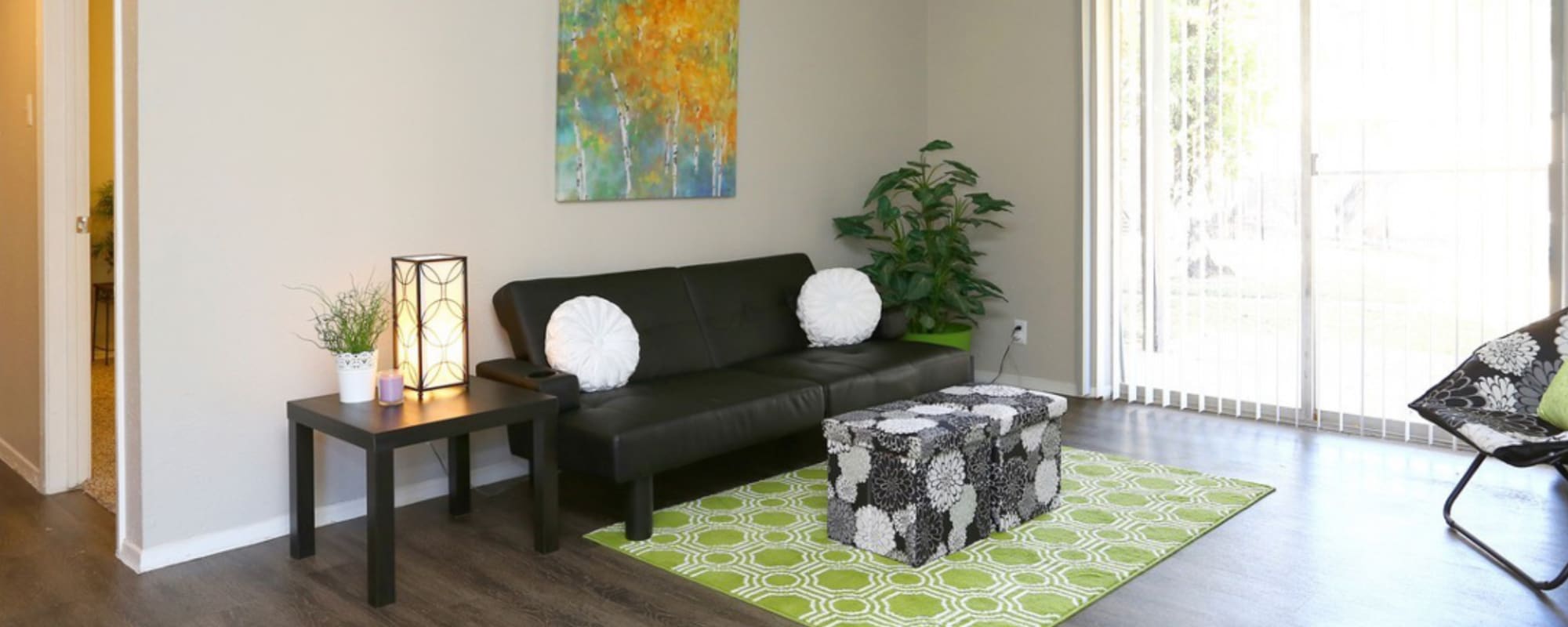 Apartment living room with wood-style flooring at Retreat at 2818 in Bryan, Texas