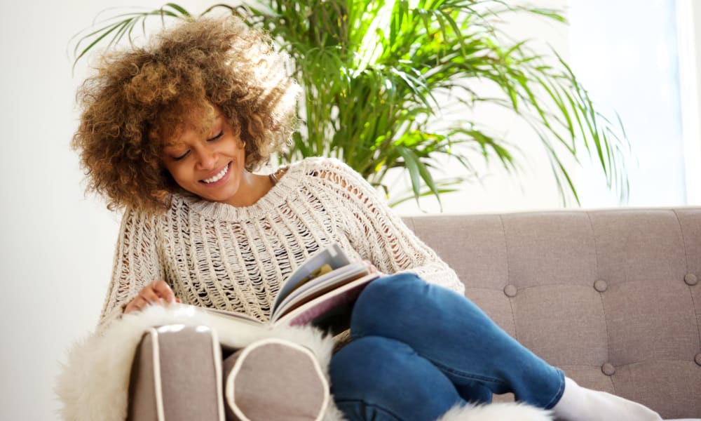 Resident on her couch reading a book in her living room at River Villas in Palmyra, New Jersey