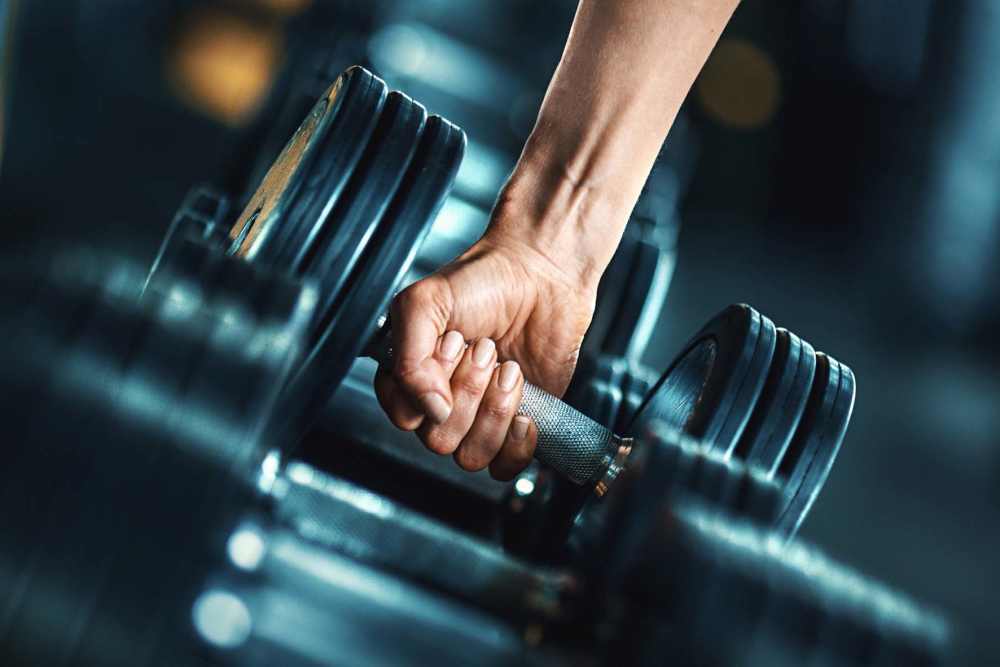 Fitness center with dumbell rack at Ennova Highlands in Arlington, Texas