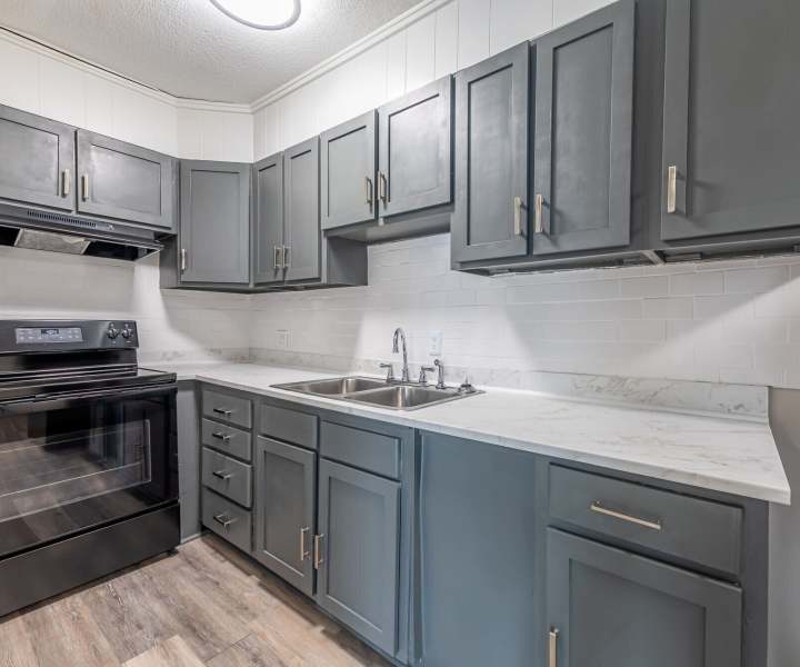 Black appliances and wooden cabinets at Lofts At Glenhaven in Winston Salem, North Carolina