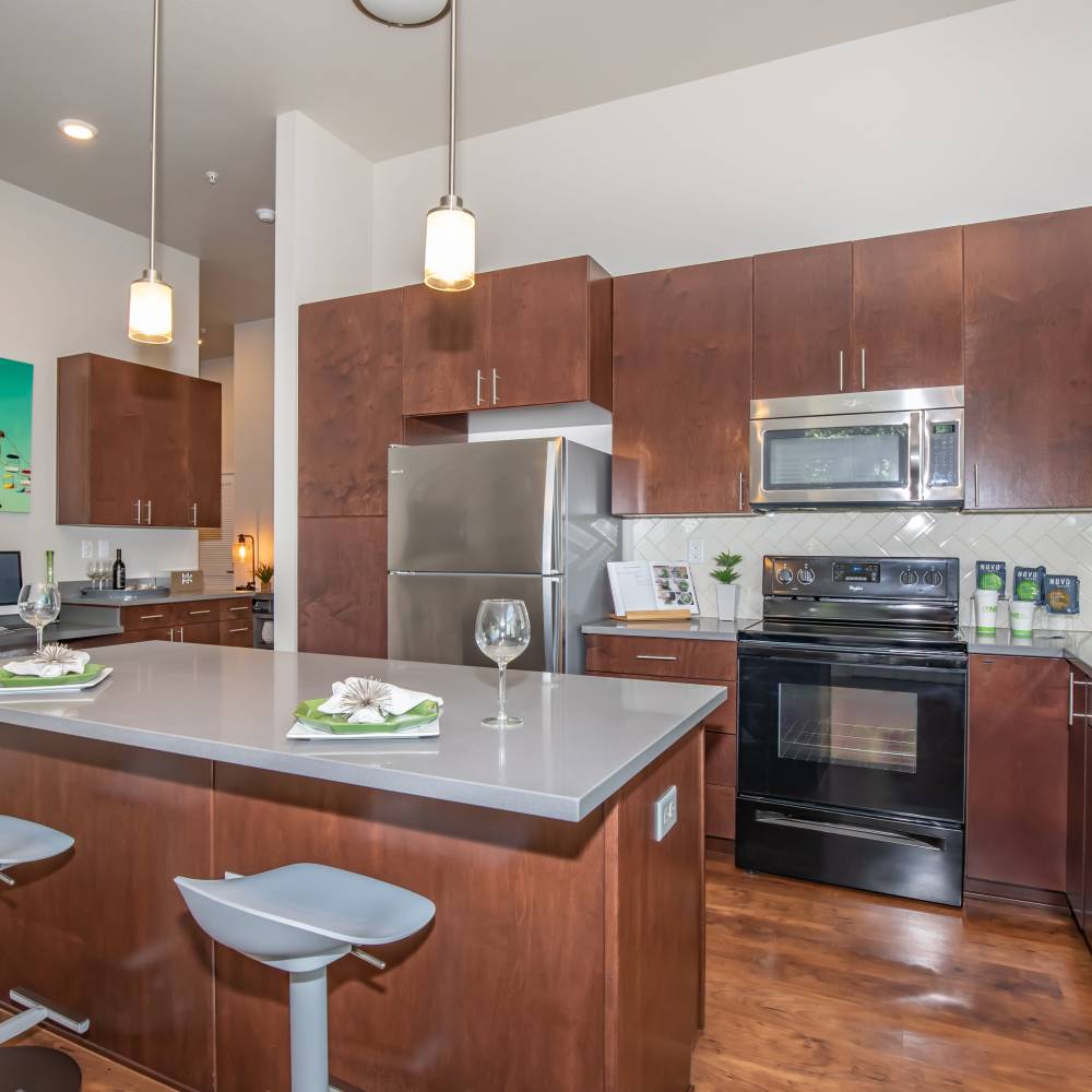Modern kitchen with island countertop and barstool at Park Place Olde Town Apartments in Arvada, Colorado