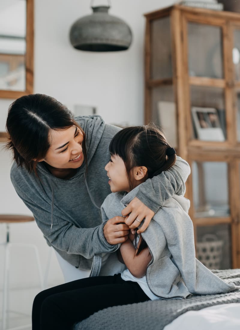 Resident embracing their kid at Whisper Creek Apartment Homes in Lakewood, Colorado