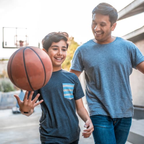 A father and his son with a basketball at Gateway Village in San Diego, California