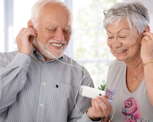 Senior couple listening to music with earbuds