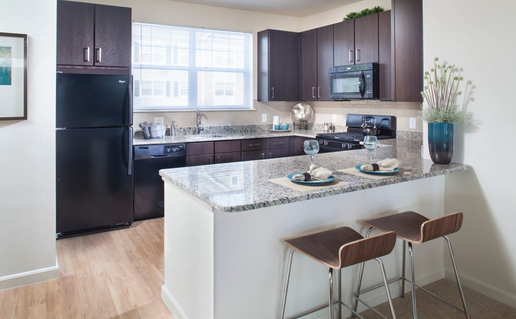 View of modern kitchen over breakfast bar in model home at Prynne Hills in Canton, Massachusetts