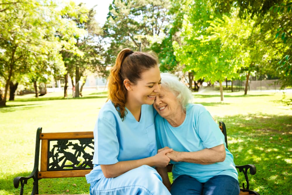 Resident and staff on park bench at Cloudberry Lodge at Brandon in Brandon, Florida