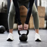 A woman lifting a dumbell in the fitness center at Riverstone in Macon, Georgia