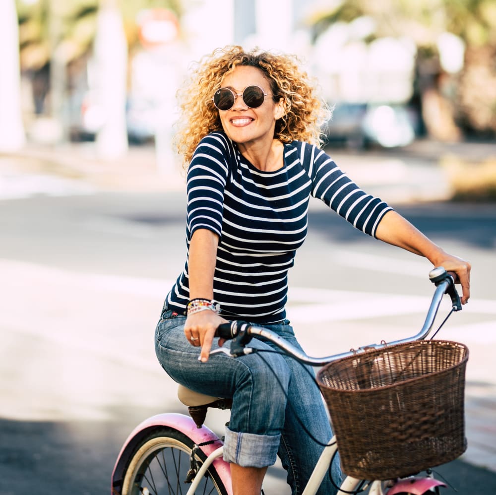 Woman riding a bike near The Columns at Westchase in Houston, Texas
