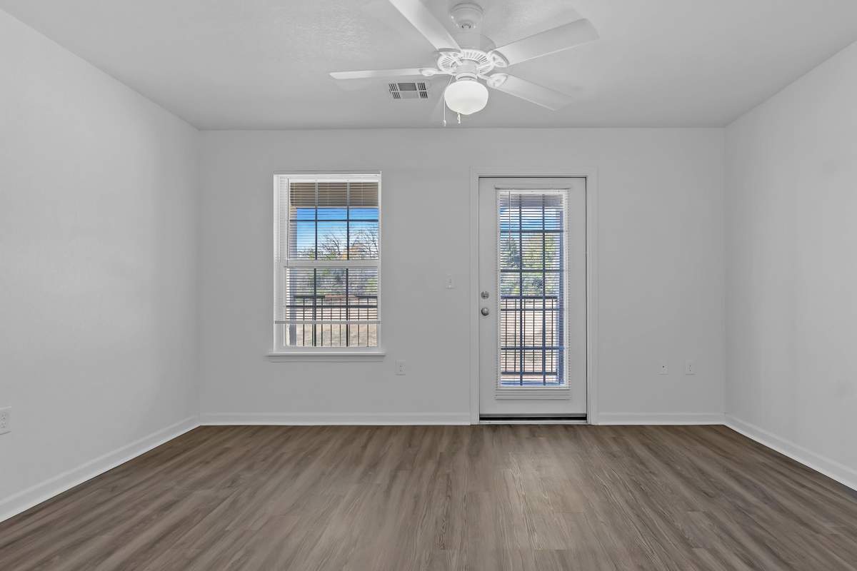 Bright room with large windows and wood-style flooring at Wickham Gardens in Sapulpa, Oklahoma