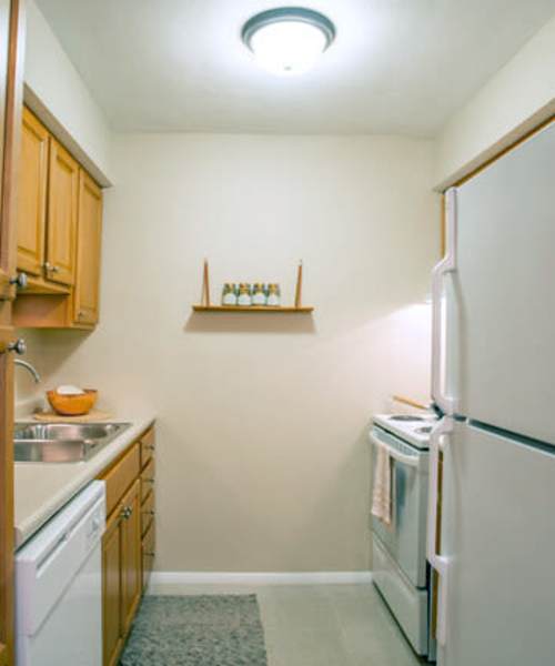 Kitchen with refrigerator at Beau Jardin Apartments in St. Louis, Missouri