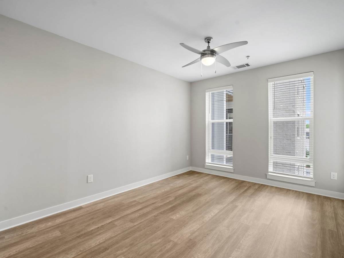 Unfurnished living room with ceiling fan and large window at The Rise at Regency in Henrico, Virginia