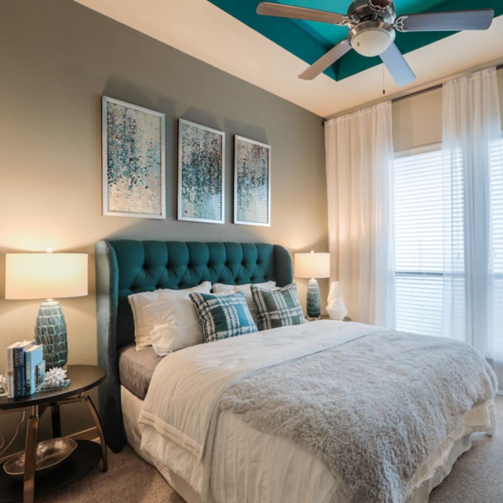 Beautiful model master bedroom with plush carpeting and a ceiling fan at Imperial Lofts in Sugar Land, Texas