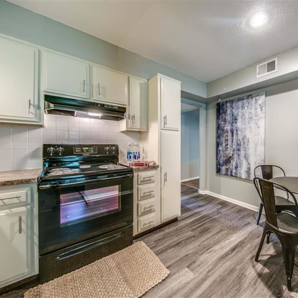 Kitchen with hardwood floors and modern appliances at London House Apartments in Lenexa, Kansas