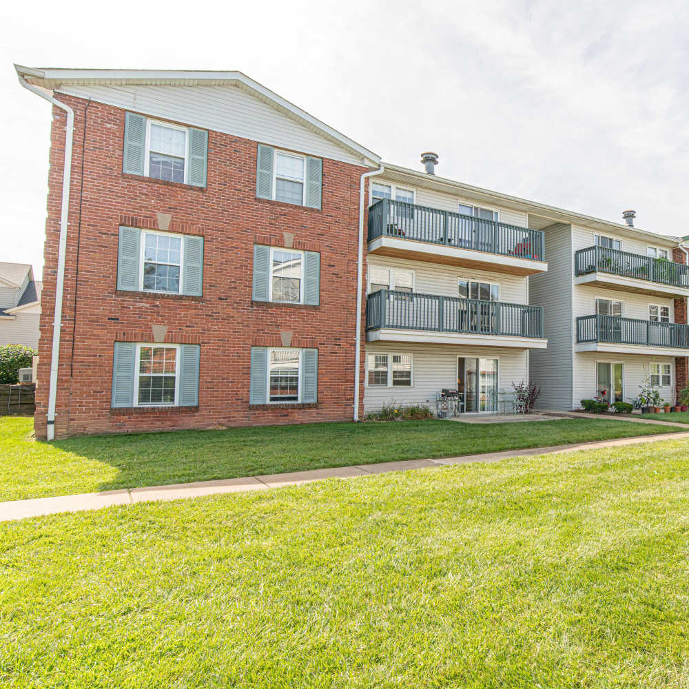 Front view of apartments with large green grass at Village Green Apartments in Chesterfield, Missouri