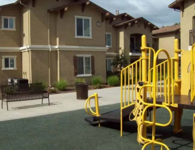 Charming playground surrounded by lush landscaping at Sommerset Place in Sacramento, California.
