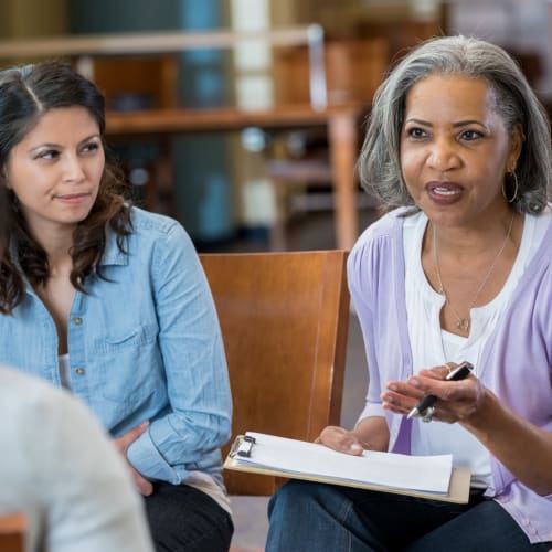 A staff member talking with residents at White Springs Senior Living in Warrenton, Virginia