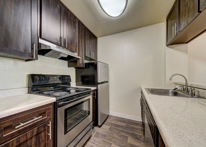 Brown Renovated Kitchen with stainless steel appliances at The Timbers Apartments in Hayward