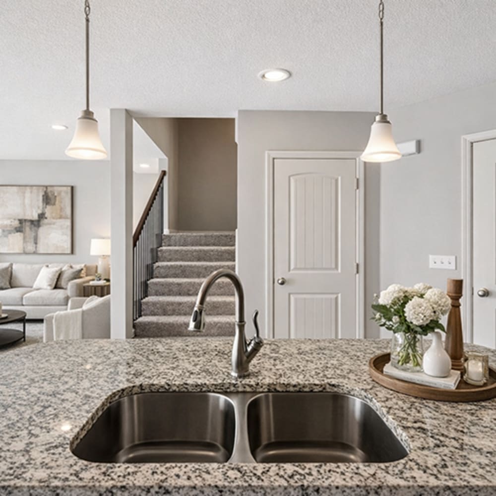 Kitchen with stainless-steel sink, granite countertop and hanging lights at Chapel Ridge in Lees Summit, Missouri