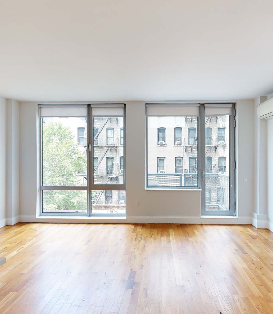 Spacious living area with large floor-to-ceiling windows for natural light and views at Leonard Pointe in Brooklyn, New York