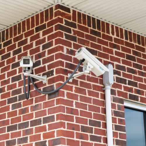 Security cameras mounted on a brick wall at Red Dot Storage in Pine Bluff, Arkansas