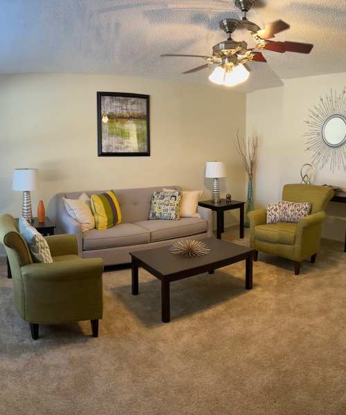 Living room with a fancy ceiling fan at MeadowView Townhomes in Goshen, Ohio